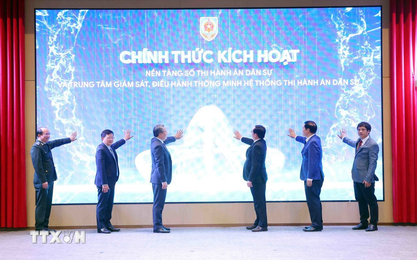 Phó Thủ tướng Hồ Quốc Dũng và Bộ trưởng Bộ Tư pháp Nguyễn Hải Ninh cùng các đại biểu thực hiện nghi thức kích hoạt nền tảng số thi hành án dân sự và Trung tâm giám sát, điều hành thông minh hệ thống thi hành án dân sự. (Ảnh: Phạm Kiên/TTXVN)