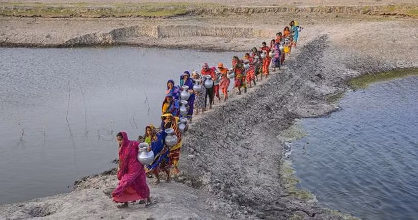 Phụ nữ tại Khulna (Bangladesh) mang nước từ nguồn nước ngọt ở xa sau khi nguồn nước uống tại địa phương bị ảnh hưởng bởi xâm nhập mặn và các vấn đề khác. (Nguồn :Getty Images)