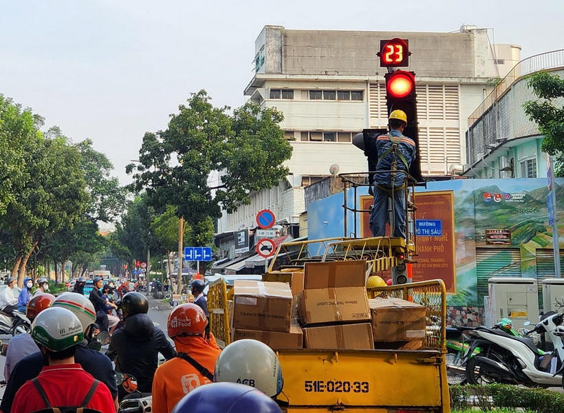 Công nhân gắn đèn tín hiệu cho phép rẽ phải khi đèn đỏ tại một số nút giao. (Ảnh: Tiến Lực/TTXVN)