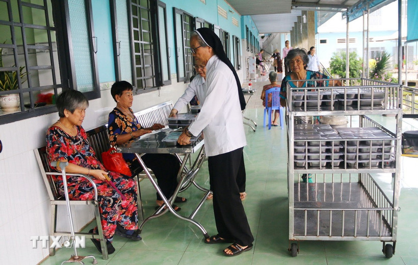 Phát cơm cho người được chăm sóc tại Cơ sở Bảo trợ xã hội dưỡng lão tình thương Suối Tiên (Đồng Nai). (Ảnh: Lê Xuân/TTXVN)