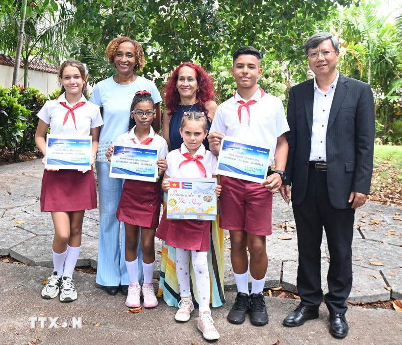 Đại sứ Việt Nam Lê Quang Long cùng các học sinh đạt giải. (Ảnh: Việt Hùng/TTXVN)