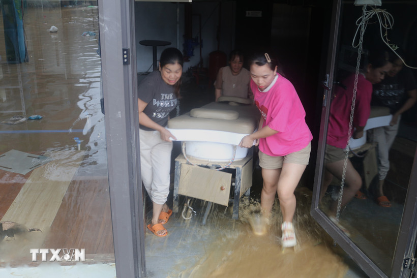 Người dân khẩn trương di dời tài sản ra khỏi vùng nguy cơ ngập lụt. (Ảnh: Chu Hiệu/TTXVN)