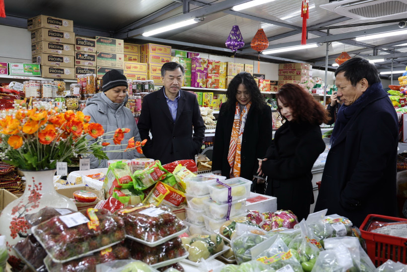 Đại sứ và phu nhân cùng lãnh đạo cộng đồng người Việt tới thăm một cửa hàng bán các sản phẩm truyền thống của Việt Nam tại Trung tâm thương mại Sapa. (Ảnh Việt Thắng/TTXVN)