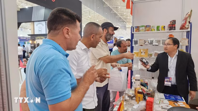 Ông Hoàng Đức Nhuận, Tham tán Thương mại Việt Nam tại Algeria giới thiệu sản phẩm cà phê Việt Nam với khách tham quan. (Ảnh: Mạnh Hùng/TTXVN)