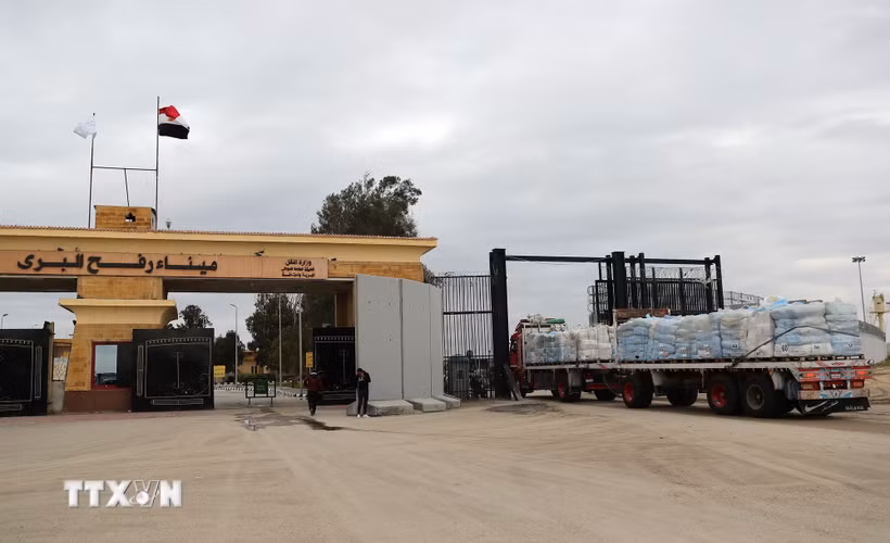 Xe chở hàng viện trợ nhân đạo đi qua cửa khẩu Rafah. (Ảnh: THX/TTXVN)