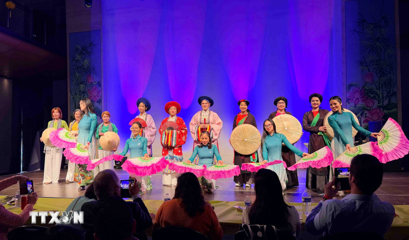 Màn trình diễn áo dài mang tên “Ba miền chung một dáng hoa”, do Câu lạc bộ Di sản Áo dài Việt Nam tại Vương quốc Bỉ phối hợp với Hội phụ nữ UGVB thực hiện. (Ảnh: Hương Giang/TTXVN)