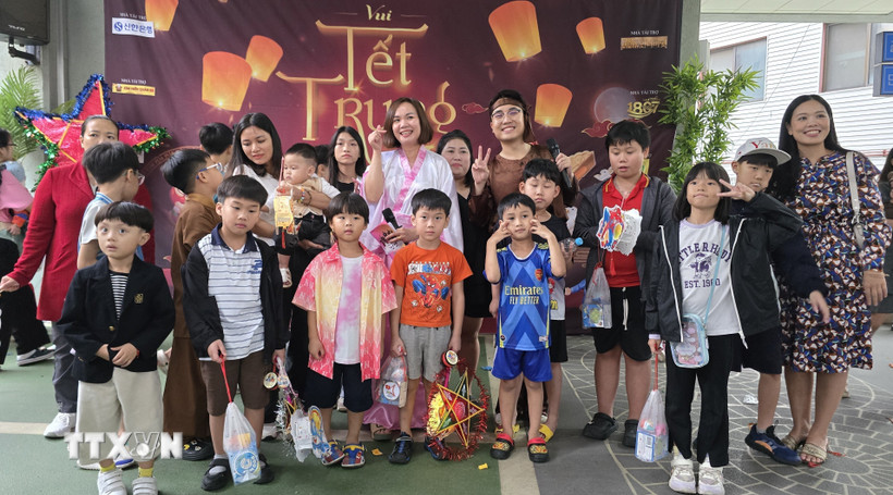 Ban tổ chức chụp ảnh kỷ niệm với các cháu thiếu nhi. (Ảnh: Đức Thắng/TTXVN)