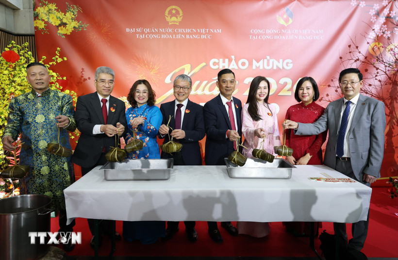 Đại sứ Nguyễn Đắc Thành (thứ2, bên trái), Phu nhân và các vị khách vớt bánh chưng mở đầu buổi lễ. (Ảnh: Thu Hằng/TTXVN)