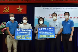Bà Tô Thị Bích Châu, Chủ tịch Ủy ban Mặt trận Tổ quốc Việt Nam Thành phố Hồ Chí Minh tiếp nhận tượng trưng sự ủng hộ từ đại diện Bộ Tài chính và Tập đoàn Bảo Việt. (Ảnh: TTXVN phát)