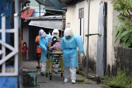 Nhân viên y tế chuyển bệnh nhân tới bệnh viện. (Ảnh: AFP/TTXVN)