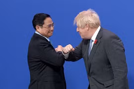 Thủ tướng Anh Boris Johnson đón Thủ tướng Phạm Minh Chính đến dự Hội nghị COP26. (Ảnh: Dương Giang/TTXVN)