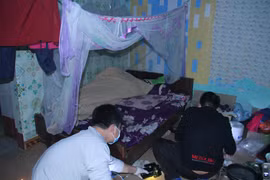 Lực lượng chức năng khám nghiệm hiện trường, nơi phát hiện thi thể nạn nhân. (Ảnh: TTXVN phát)