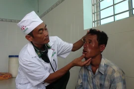 Nhân viên quân y Đồn Biên phòng Cửa Đại chăm sóc ngư dân gặp nạn. (Ảnh: Trần Thị Thu Hiền/TTXVN)