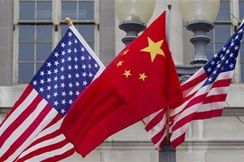Quốc kỳ Trung Quốc (giữa) và quốc kỳ Mỹ. (Ảnh: Getty Images/TTXVN)
