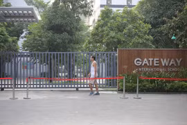 Một người dân đi ngang qua cổng Trường Gateway. (Ảnh: Minh Sơn/Vietnam+)