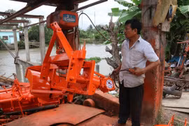Ông Dương Quốc Thái vận hành thử máy đắp bờ. (Ảnh: Minh Trí-TTXVN)