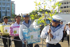 Cán bộ, chiến sỹ Vùng 2 Hải quân vận chuyển quà Tết lên tàu cho chuyến hành trình. (Ảnh: Hoàng Nhị/TTXVN)