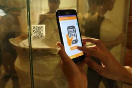 Sử dụng thiết bị di động để quét mã QR được gắn cho hiện vật để nghe thông tin thuyết minh về hiện vật tại Bảo tàng Đà Nẵng. (Ảnh: Trần Lê Lâm/Vietnam+)