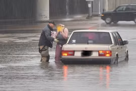Nhân viên cứu hộ hỗ trợ một công dân bị mắc kẹt trong nước lũ. (Nguồn: accuweather.com)