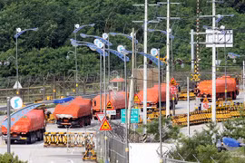 Xe chở gạo của Hàn Quốc đi qua trạm kiểm soát ở thành phố biên giới liên Triều Paju để vào Triều Tiên. (Ảnh: AFP/TTXVN)