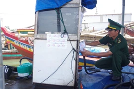 Lực lượng chức năng niêm phong các thiết bị của Hợp tác xã Sản xuất và Dịch vụ Sông Lam. (Ảnh: TTXVN)