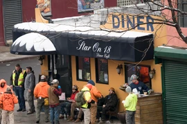 Các công nhân xây dựng trong giờ nghỉ giải lao tại một quán càphê ở New York, Mỹ. (Ảnh: AFP/TTXVN)