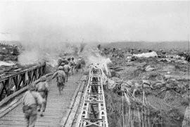 Bộ đội ta vượt qua cầu Mường Thanh, tấn công vào Sở chỉ huy Tập đoàn cứ điểm Điện Biên Phủ, chiều 7/5/1954. (Ảnh: Tư liệu TTXVN)