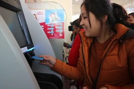 Khách hàng trải nghiệm dịch vụ tại ngân hàng tự động AutoBank CDM của Agribank. (Ảnh: Nguyễn Dũng/TTXVN)