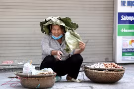 Người lao động dùng đủ mọi cách để chống chọi với nắng nóng gay gắt ngoài đường lên đến hơn 40 độ C. (Ảnh: Thành Đạt/TTXVN)