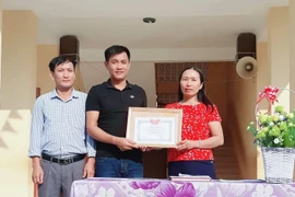Tặng Giấy khen thầy giáo Đồng Văn Nhân vì hành động dũng cảm cứu người. (Ảnh: Bích Huệ/TTXVN)