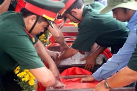 Các lực lượng làm công tác chuẩn bị an táng hài cốt các Anh hùng liệt sỹ. (Ảnh: Trịnh Bang Nhiệm/TTXVN)