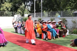 Đại sứ Phạm Sanh Châu trình diễn áo dài nam. (Ảnh: Huy Lê/Vietnam+)