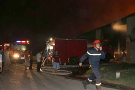 Cảnh sát Phòng cháy chữa cháy đến hiện trường dập lửa. (Ảnh:Trịnh Duy Hưng/TTXVN)