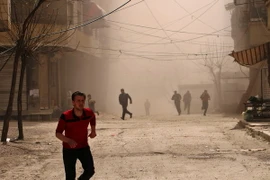 Người dân Syria tìm nơi ẩn náu trong một đợt không kích ở Ain Tarma, thuộc khu vực Đông Ghouta ngày 27/3. (Nguồn: AFP/TTXVN)