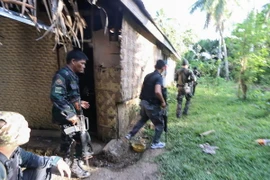 Cảnh sát và binh sỹ Philippines trong chiến dịch truy quét các phần tử Abu Sayyaf ở thị trấn Inabanga, tỉnh Bolo, miền trung Philippines ngày 11/4. (Nguồn: AFP/TTXVN)