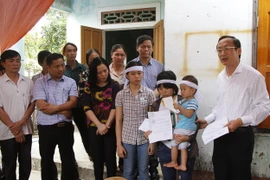 Phó Chủ tịch UBND tỉnh Hà Tĩnh Đặng Ngọc Sơn đến thăm hỏi, động viên, gửi Thư khen và quà của Chủ tịch nước cho em Nguyễn Thị Sáng. (Ảnh: Phan Đình Quân/TTXVN)