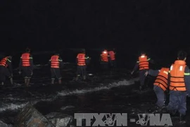 Lực lượng cứu hộ tìm kiếm các nạn nhân. (Ảnh: TTXVN)