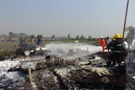 Lính cứu hỏa dập lửa bùng lên từ xác máy bay bị rơi gần Naypyidaw. (Nguồn: AFP/TTXVN)