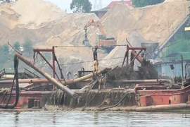 Lợi dụng “tấm bùa” nạo vét, doanh nghiệp đã ngang nhiên sử dụng tàu hút cát công suất lớn để “rút ruột” lòng sông Hồng. (Ảnh: PV/Vietnam+)