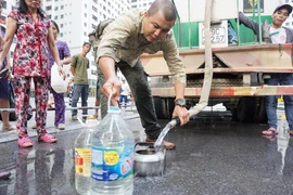 Người dân Hà Nội phải mua, hoặc nhận nước sạch để sử dụng. (Ảnh: PV/Vietnam+)