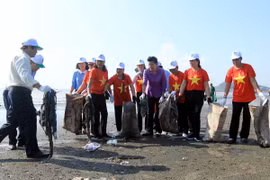 Thứ trưởng Võ Tuấn Nhân (ngoài cùng bên trái) và các đại biểu với cán bộ hội viên phụ nữ tại địa phương thu gom rác thải dọc bờ biển Đồ Sơn. (Ảnh: An Đăng/TTXVN