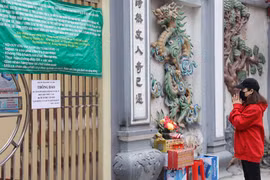 Người dân nghiêm túc thực hiện quy định không tụ tập tại các địa điểm đông đúc mà chỉ đứng từ xa vái vọng. (Ảnh: Hoài Nam/Vietnam+)