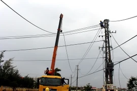 Công nhân điện lực Phú Yên khẩn trương khôi phục lại mạng lưới điện 220KV ở thành phố Tuy Hòa bị ngã đổ. (Ảnh: Thế Lập/TTXVN)