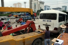 Di chuyển xe vi phạm tại một “bến cóc” ở khu vực gần bến xe Mỹ Đình. (Ảnh: Huy Hùng/TTXVN)