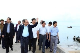 Thủ tướng Nguyễn Xuân Phúc kiểm tra công tác khắc phục hậu quả cơn bão số 12 tại huyện Vạn Ninh. (Ảnh: Thống Nhất/TTXVN)