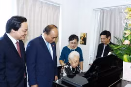 Thủ tướng Nguyễn Xuân Phúc tặng hoa và chúc mừng nghệ sỹ dương cầm Thái Thị Liên. (Ảnh: Thống Nhất/TTXVN)