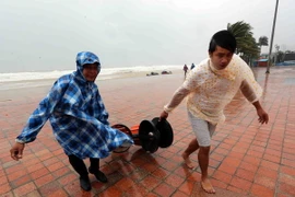 Người dân thu dọn các vật dụng bị gió quật gây hư hỏng tại Công viên biển Đông (Đà Nẵng). (Ảnh: Trần Lê Lâm/TTXVN)