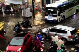 Các phương tiện giao thông di chuyển khó khăn do nước ngập tại khu vực ngã tư đường Calmette, Quận 1, Tp. Hồ Chí Minh. (Ảnh: TTXVN phát)