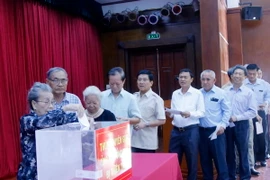 Đông đảo bà con cộng đồng người Việt đang làm ăn sinh sống tại Lào và các nhân viên Đại sứ quán Việt Nam tại Lào đã đến ủng hộ bà con bị thiên tai trong cơn bão 12. (Ảnh: Phạm Kiên/Vietnam+)