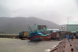 Một tàu cá của ngư dân Bình Định bị sóng đánh va kẹt vào kè đá tại Cảng cá Quy Nhơn. (Ảnh: Phạm Kha/TTXVN)